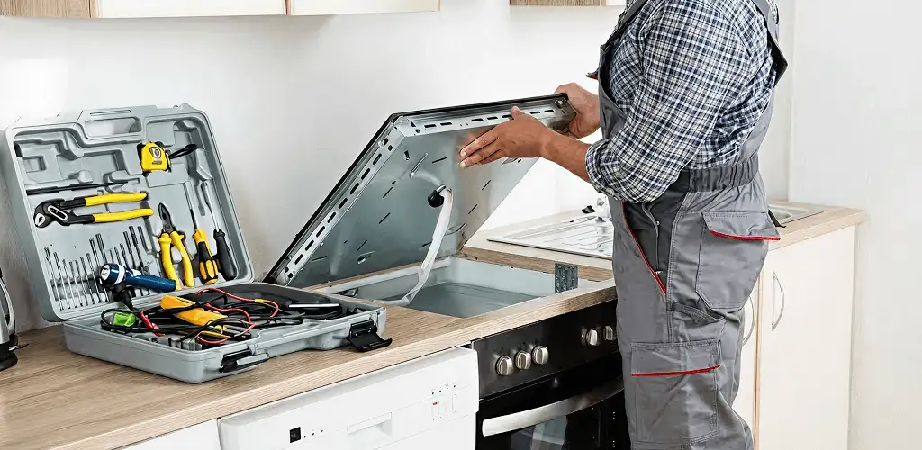 Handyman repairing a cooktop and checking wiring connections in Boulder, CO
