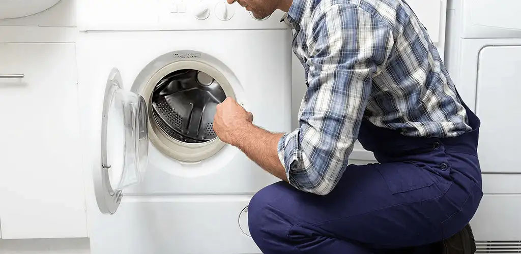 Handyman inspecting a dryer drum and internal parts for repair in Boulder, CO
