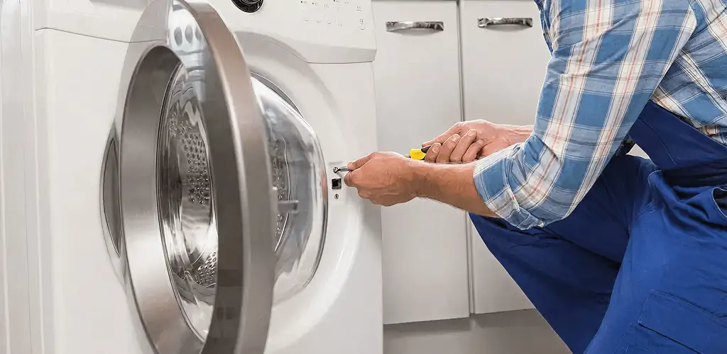 Handyman repairing a clothes dryer and checking electrical connections in Boulder, CO