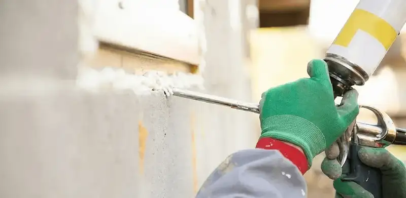 Handyman sealing exterior gaps with caulk for weatherproofing in Boulder, CO