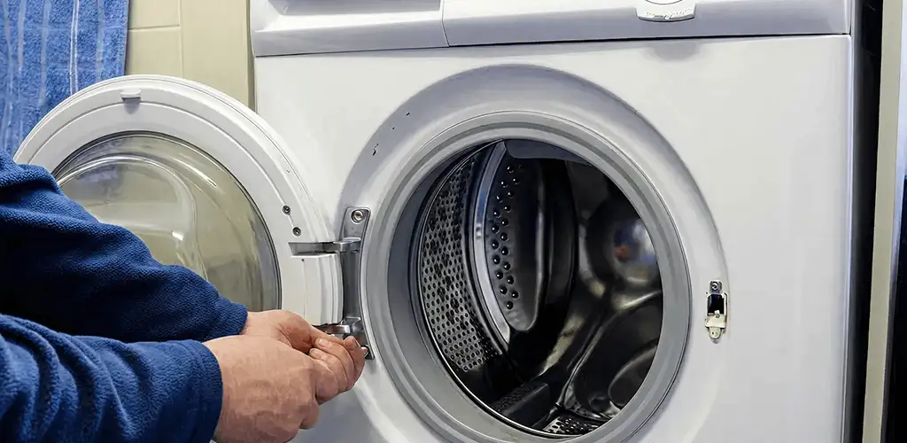 Washing machine repair handyman checking a front-load washer door and latch in Boulder, CO