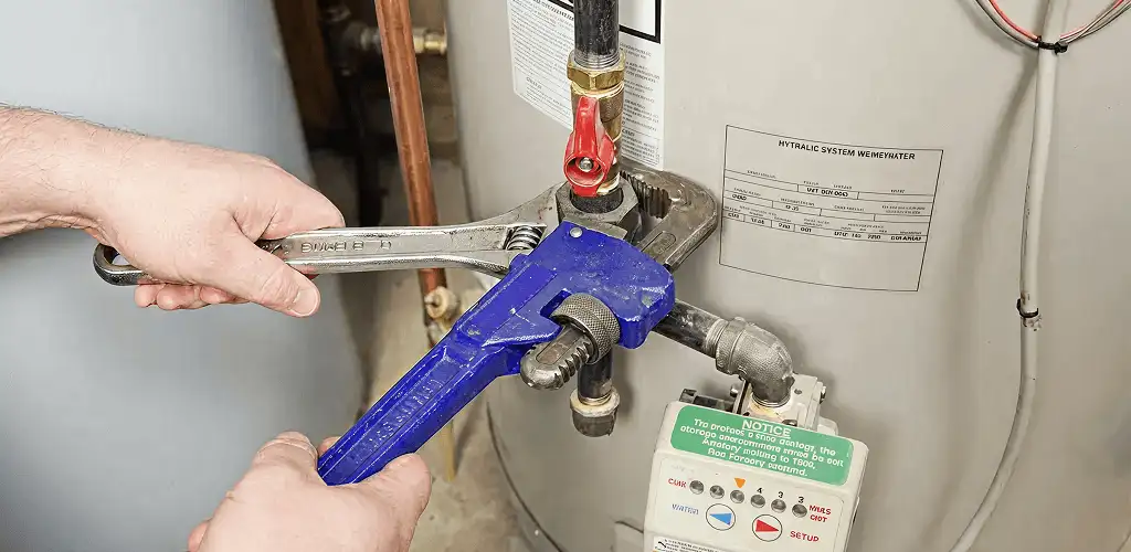 Water heater repair technician tightening the shutoff valve and supply line in Boulder, CO